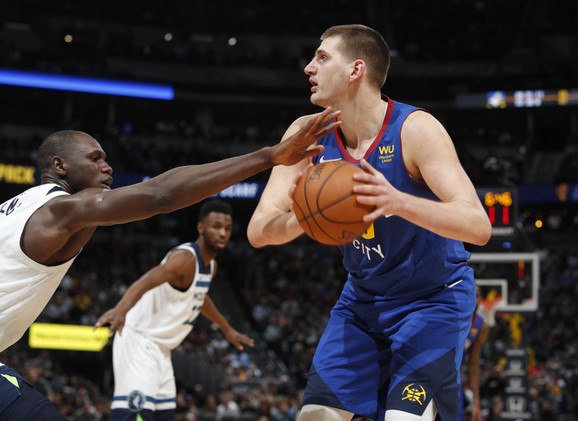 Nikola Jokić i Gorgui Dieng iz Minesote u deulu na meču NBA lige u Denveru